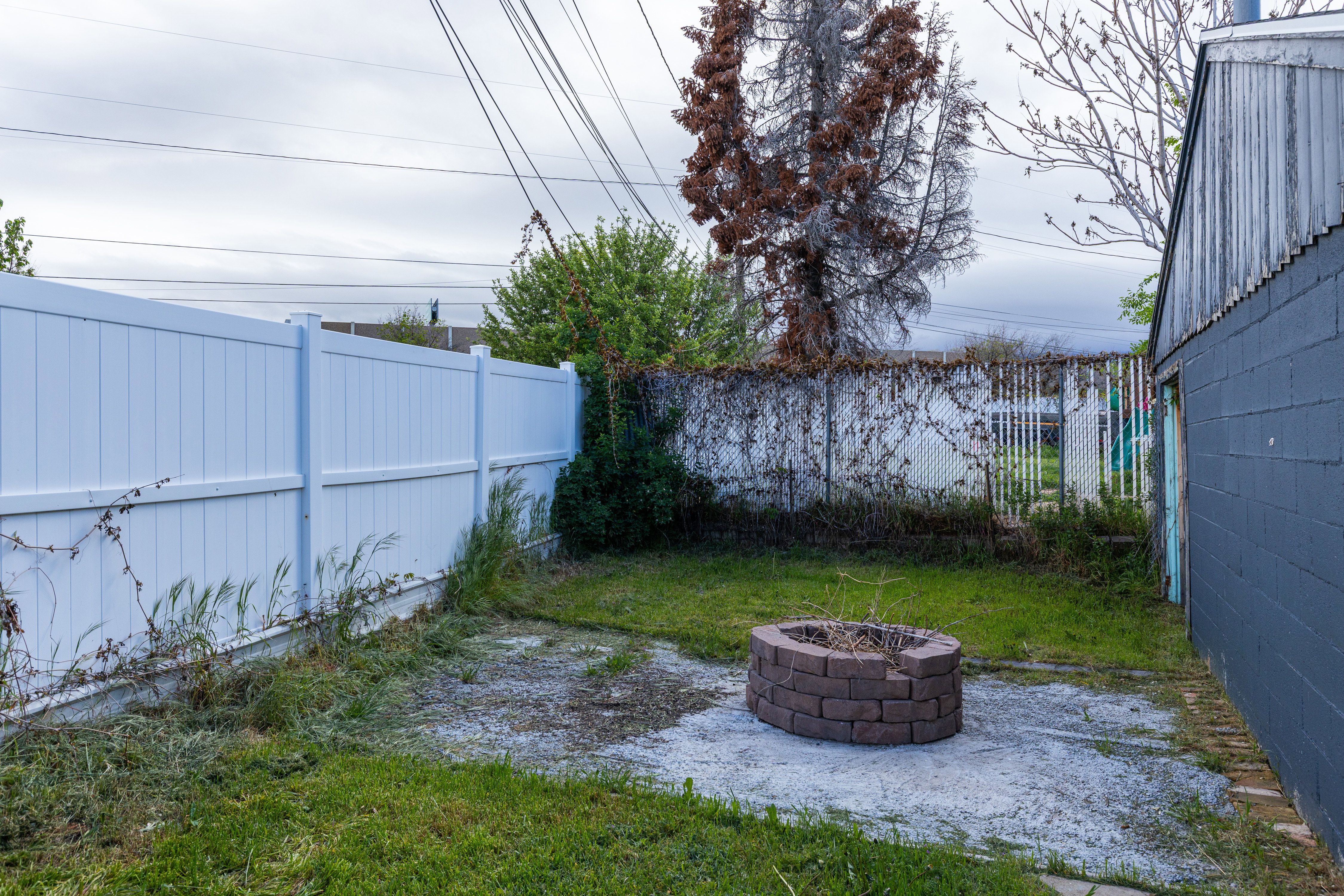 Fenced backyard with an outdoor fire pit