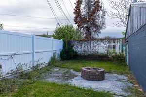 Fenced backyard with an outdoor fire pit