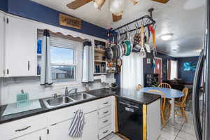 Kitchen featuring dark countertops, white cabinetry, a peninsula, a textured ceiling, and ceiling fan