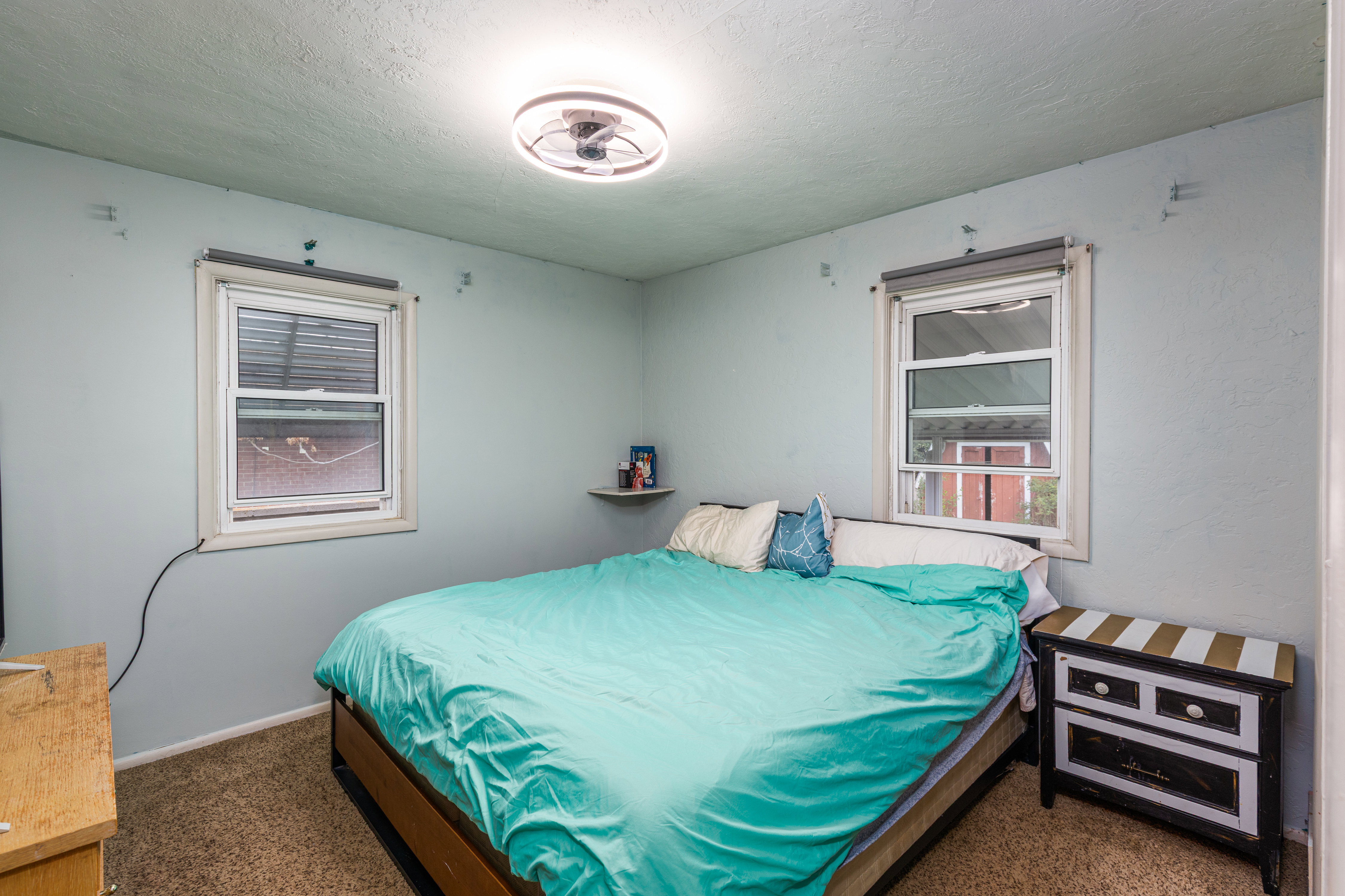 Bedroom featuring dark colored carpet and a textured ceiling