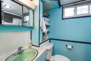 Full bath featuring vanity, curtained shower, and a wainscoted wall