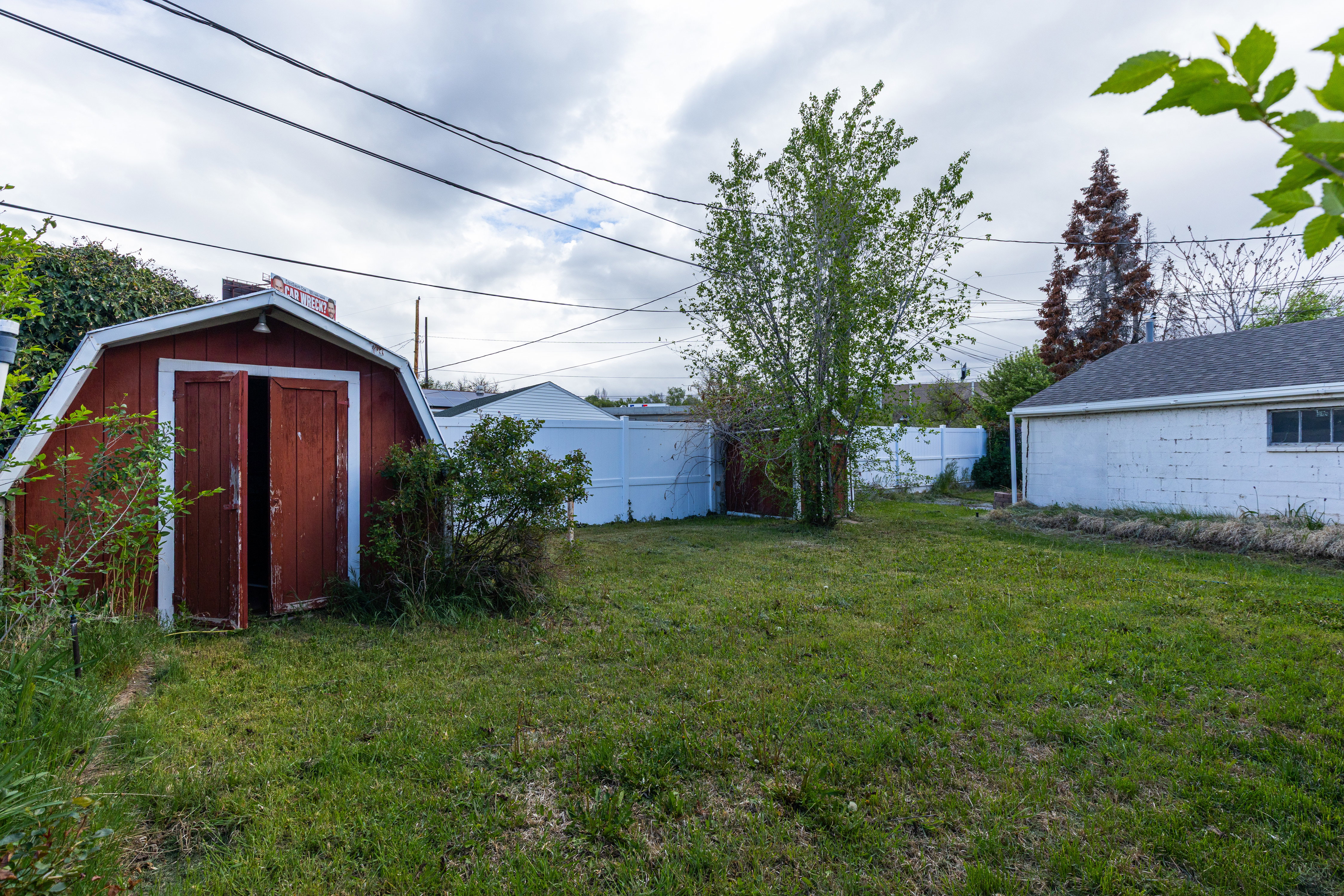 Fenced backyard featuring a shed