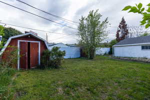 Fenced backyard featuring a shed