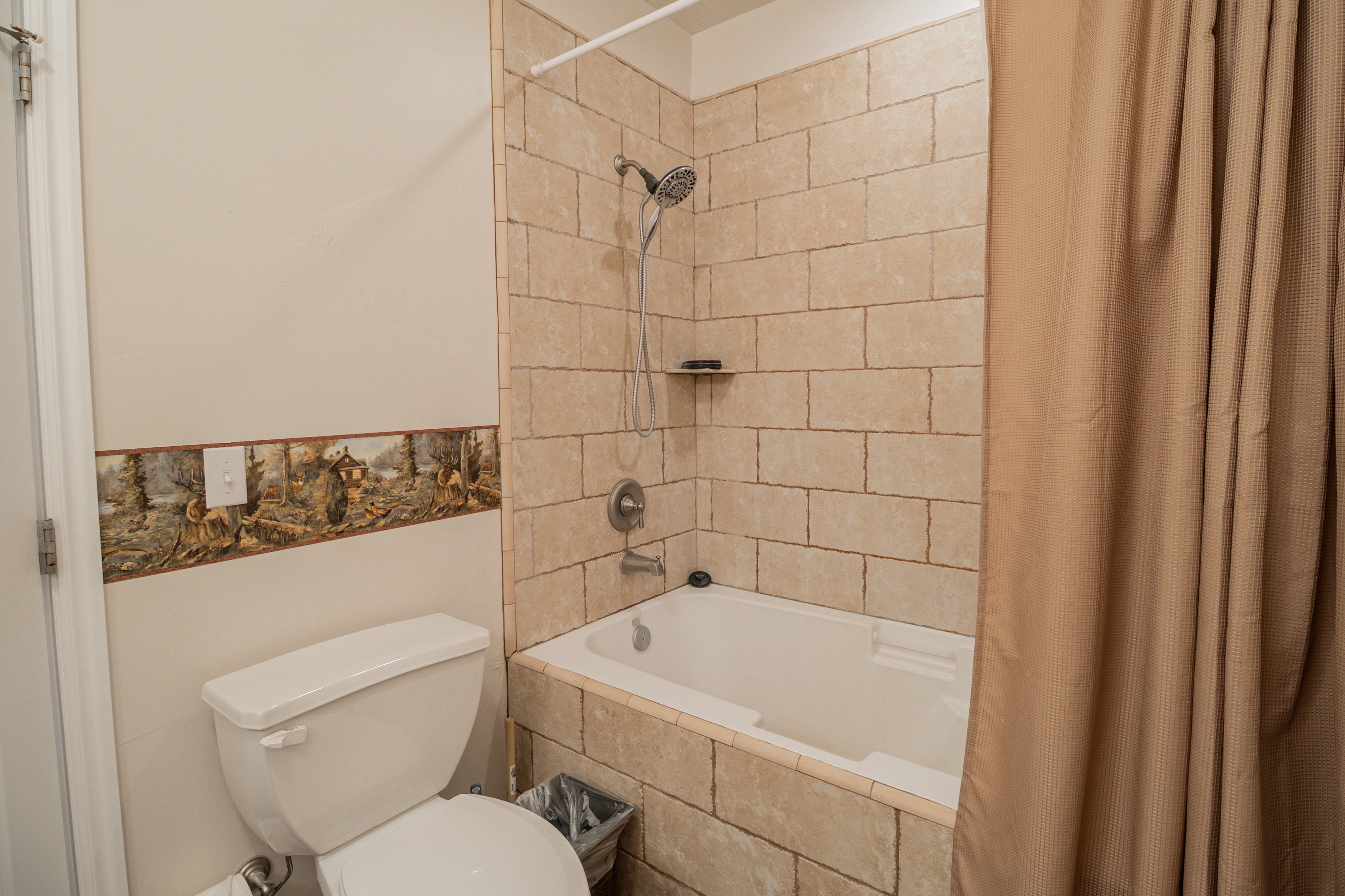 Bathroom featuring toilet and tiled shower / bath