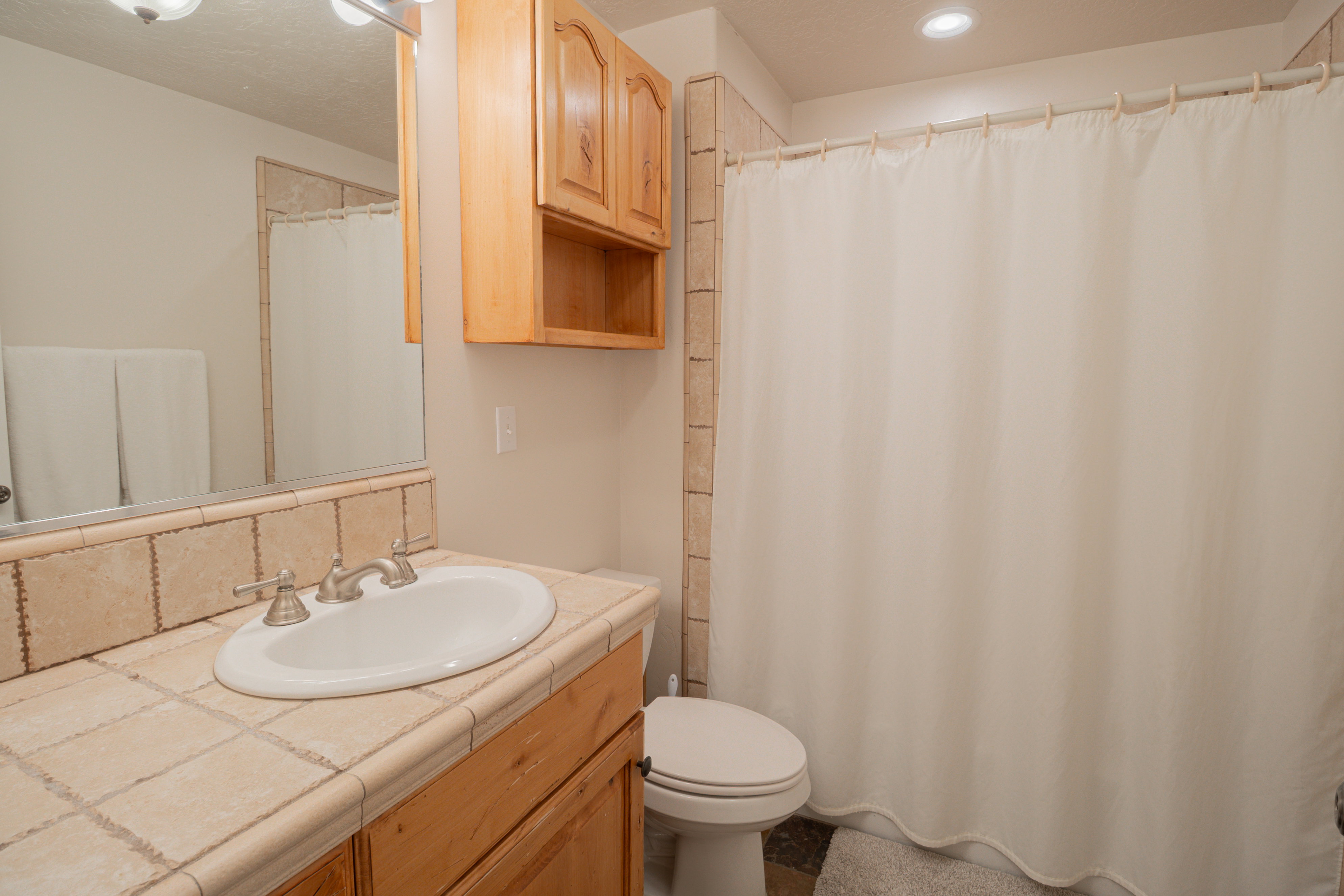 Bathroom with a shower with curtain and vanity