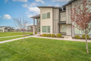 View of front of home featuring a front yard, a residential view, and stucco siding