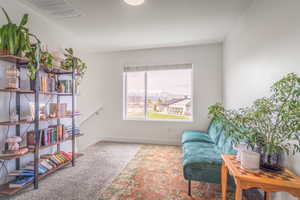 Living area with light colored carpet and baseboards