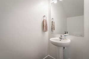 Bathroom featuring lofted ceiling and a sink