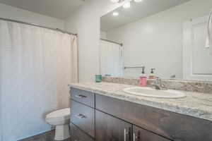 Full bathroom with vanity, dark wood-style flooring, curtained shower, and recessed lighting