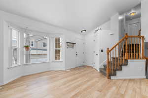 Foyer with stairs and light wood-type flooring