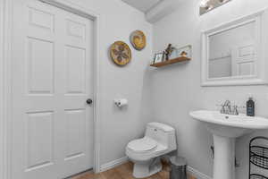 Bathroom featuring toilet and light wood finished floors