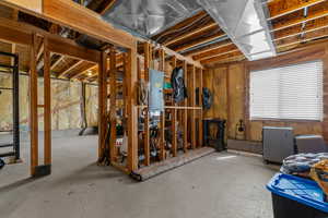 Miscellaneous room featuring electric panel, radiator, and unfinished concrete floors