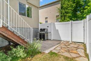 View of side of home with stucco siding and a gate