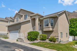 View of front of house featuring stucco siding, a garage, and concrete driveway