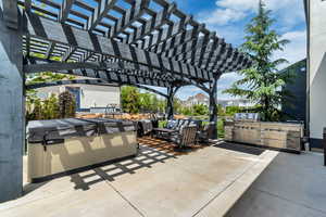 Backyard patio with pergola, outdoor kitchen, hot tub and outdoor shower with water heater.
