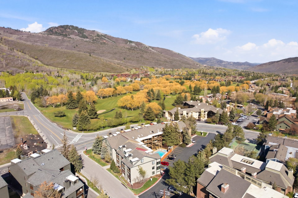 Aerial view of residential area featuring a mountain backdrop and a golf course