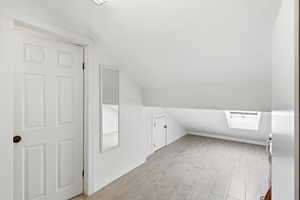 Bonus room featuring vaulted ceiling and light wood-type flooring