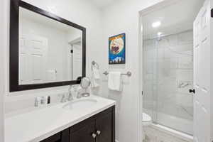 Full bathroom with vanity and a marble finish shower