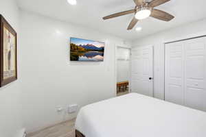 Bedroom with light wood-style floors, a ceiling fan, a closet, and recessed lighting