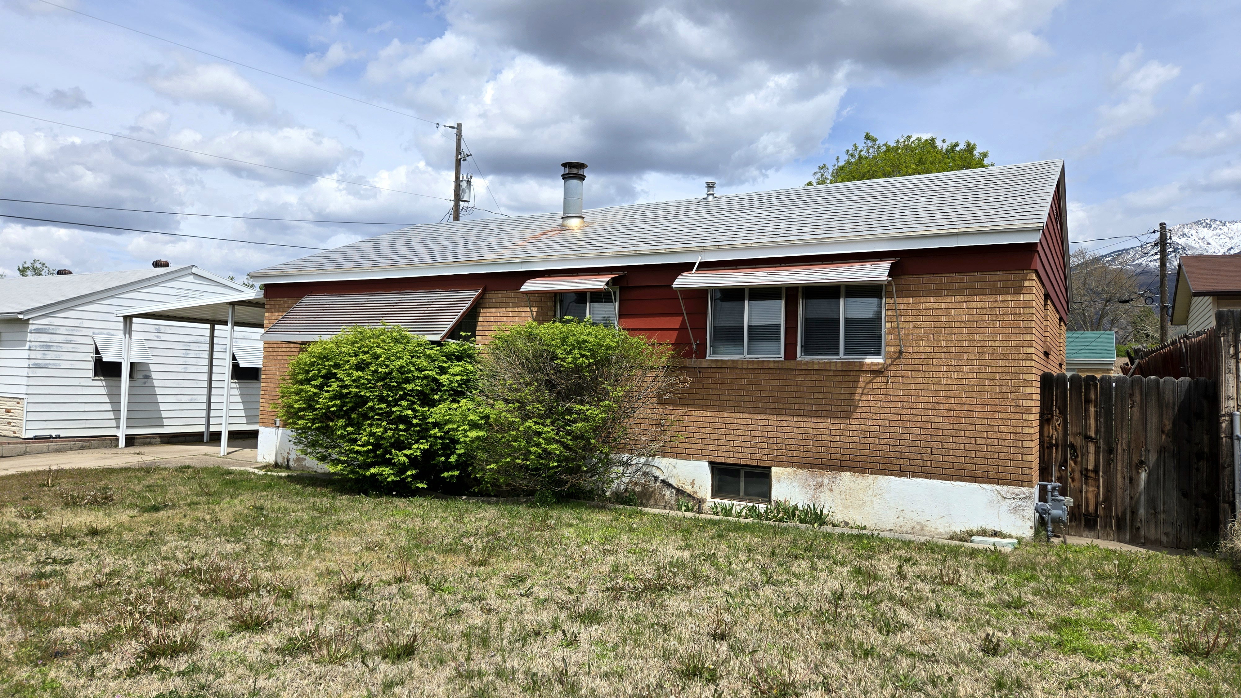 View of property exterior featuring brick siding and roof with shingles