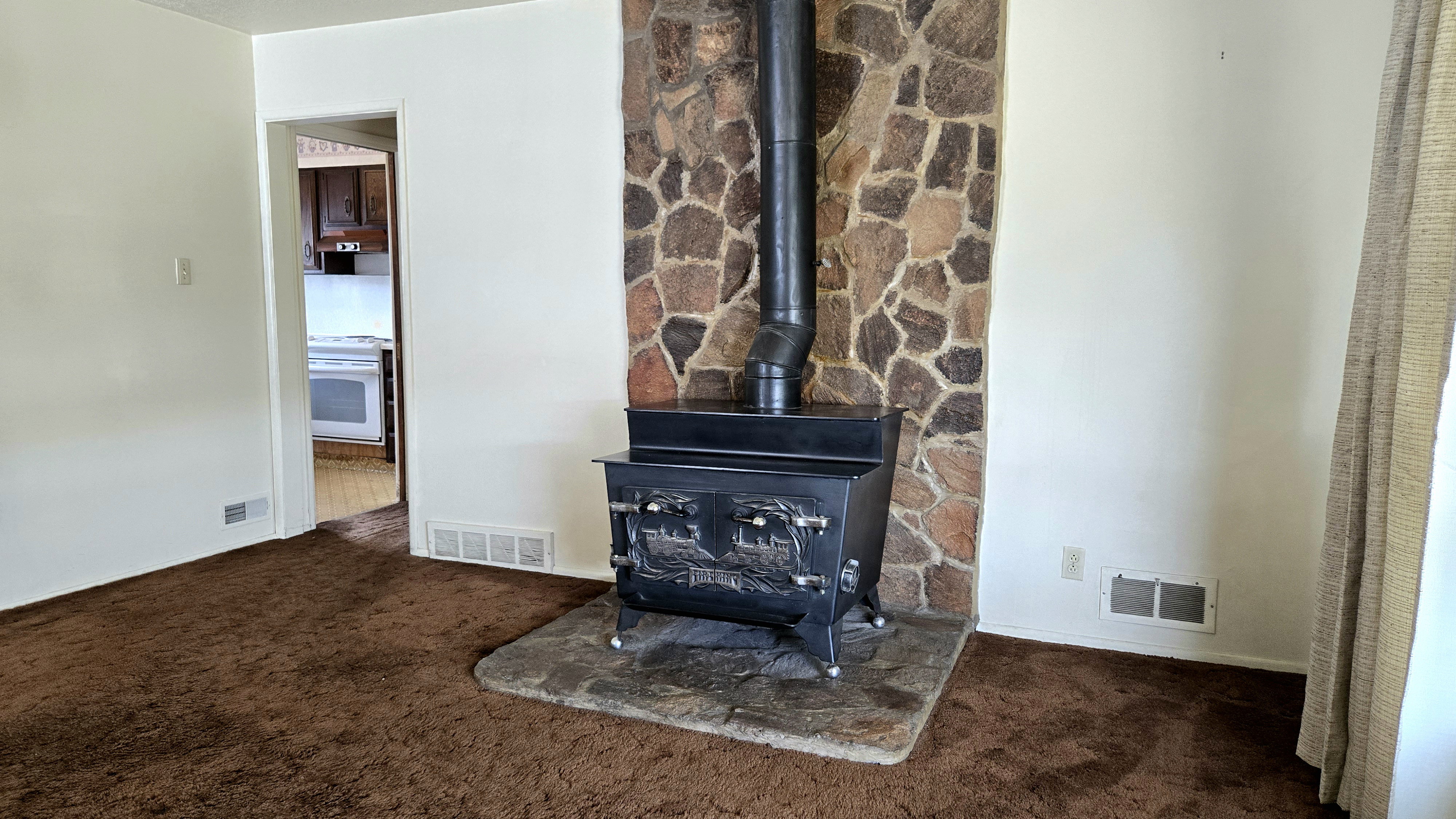 Detailed view of carpet, a wood stove, and white range oven