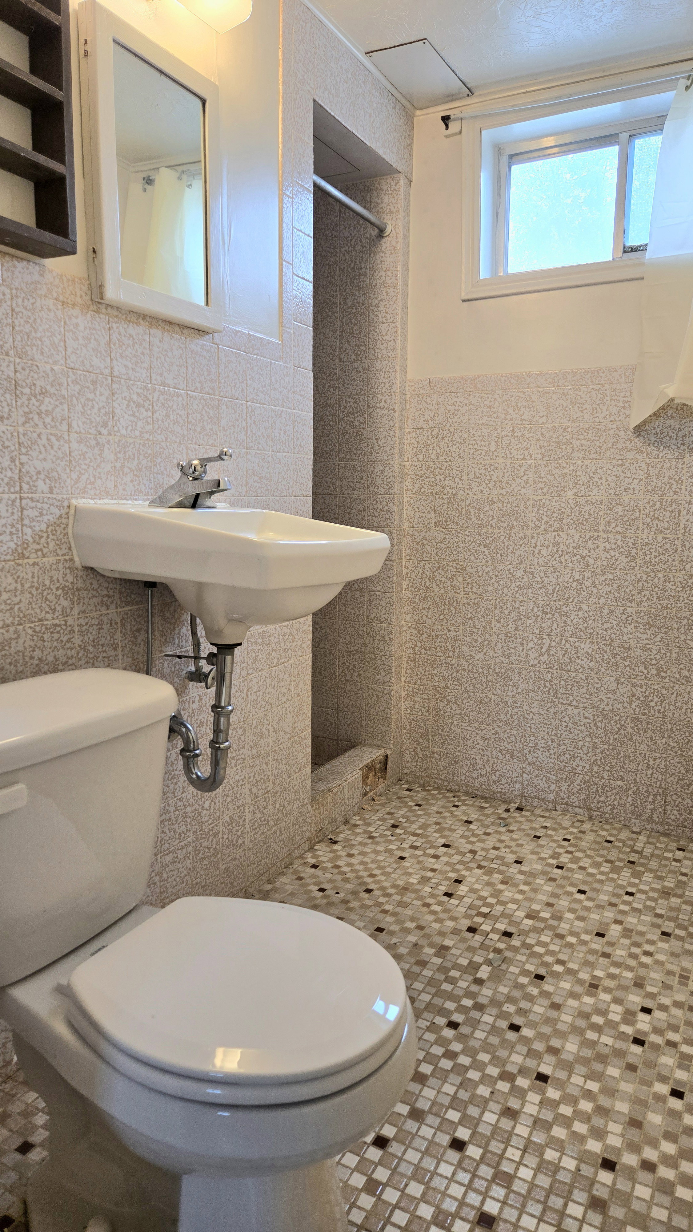 Bathroom with a stall shower, tile walls, and tile patterned flooring