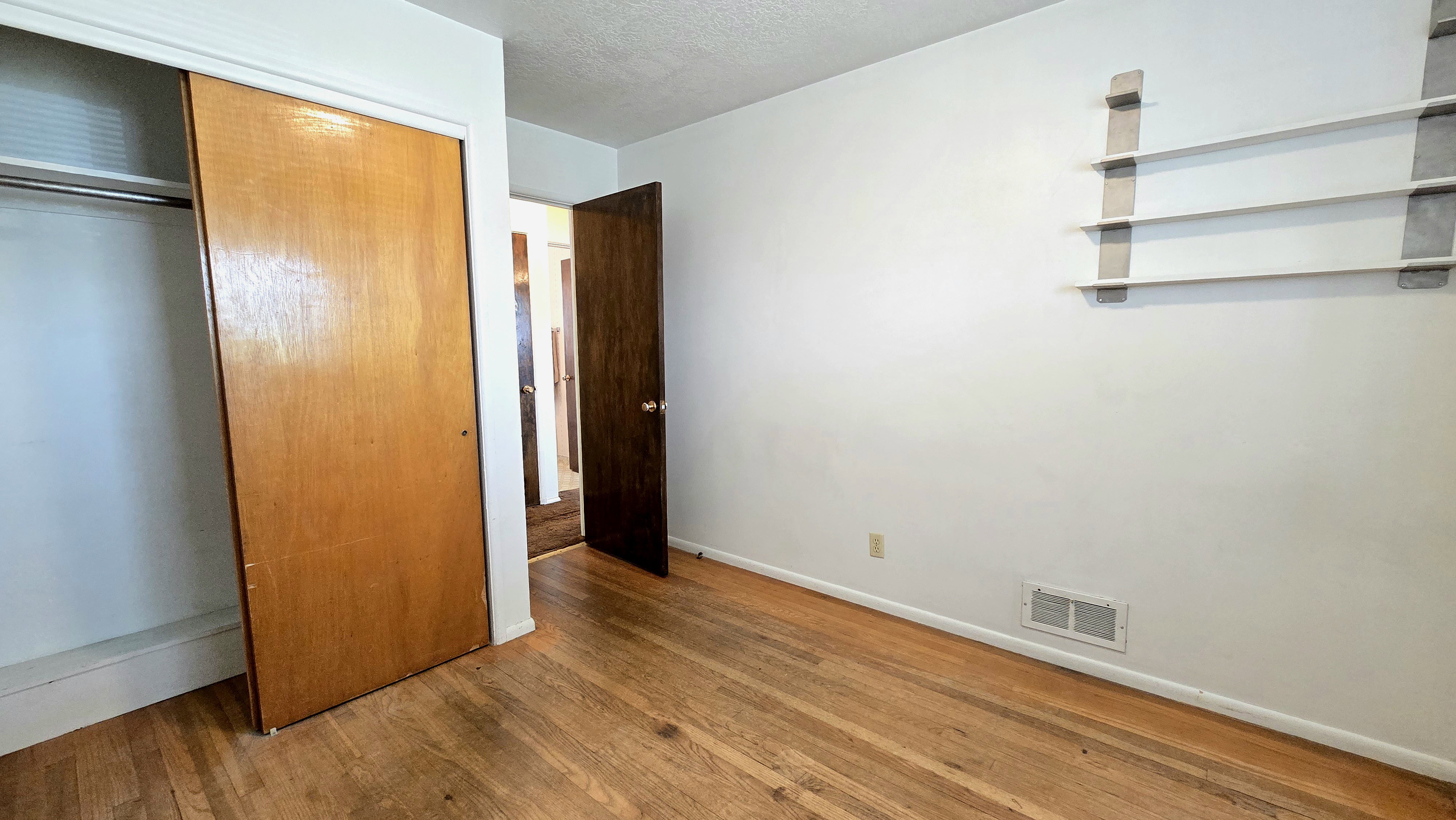 Unfurnished bedroom featuring light wood-style flooring, a closet, and a textured ceiling