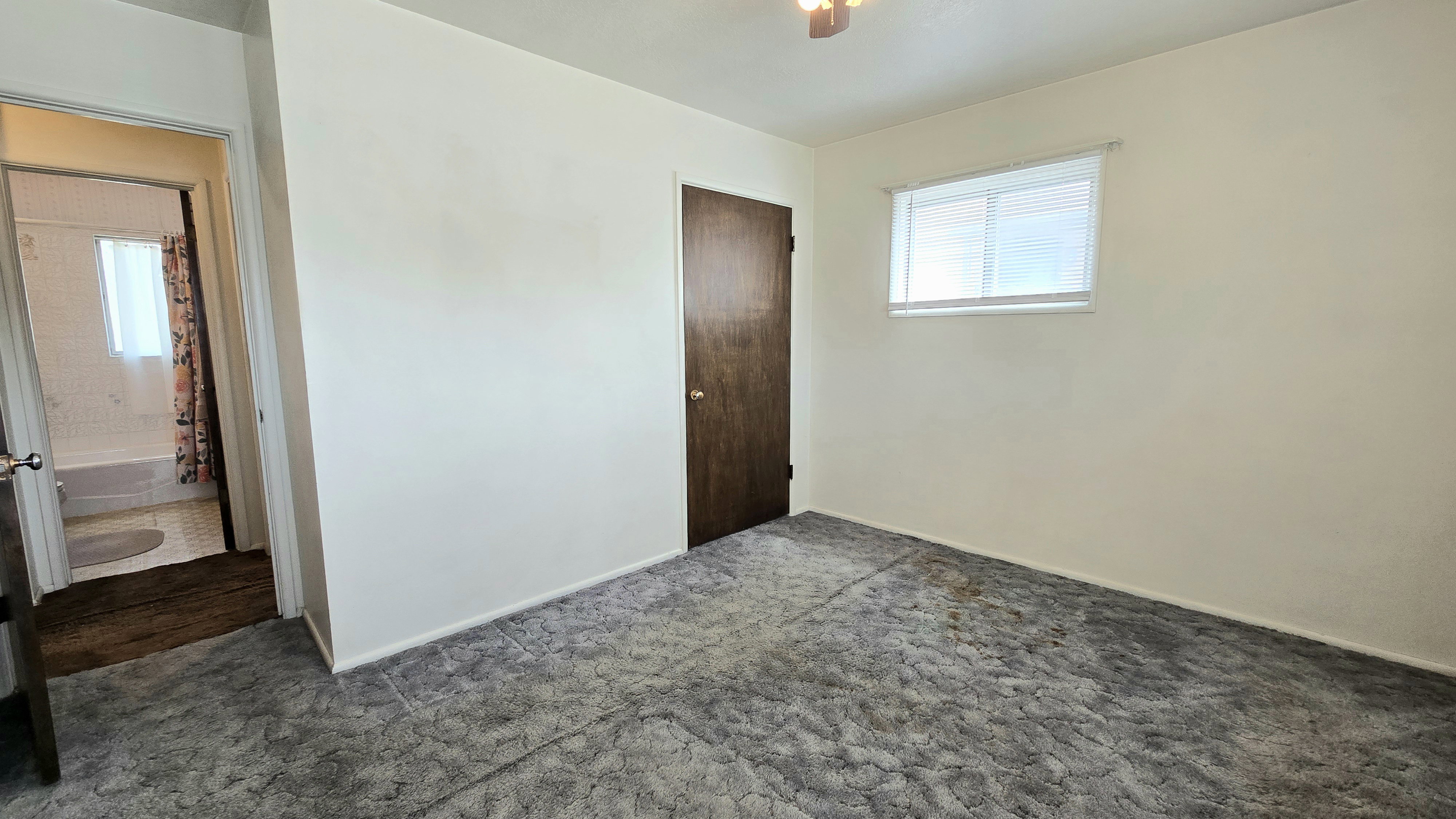 Unfurnished bedroom featuring dark carpet and a closet
