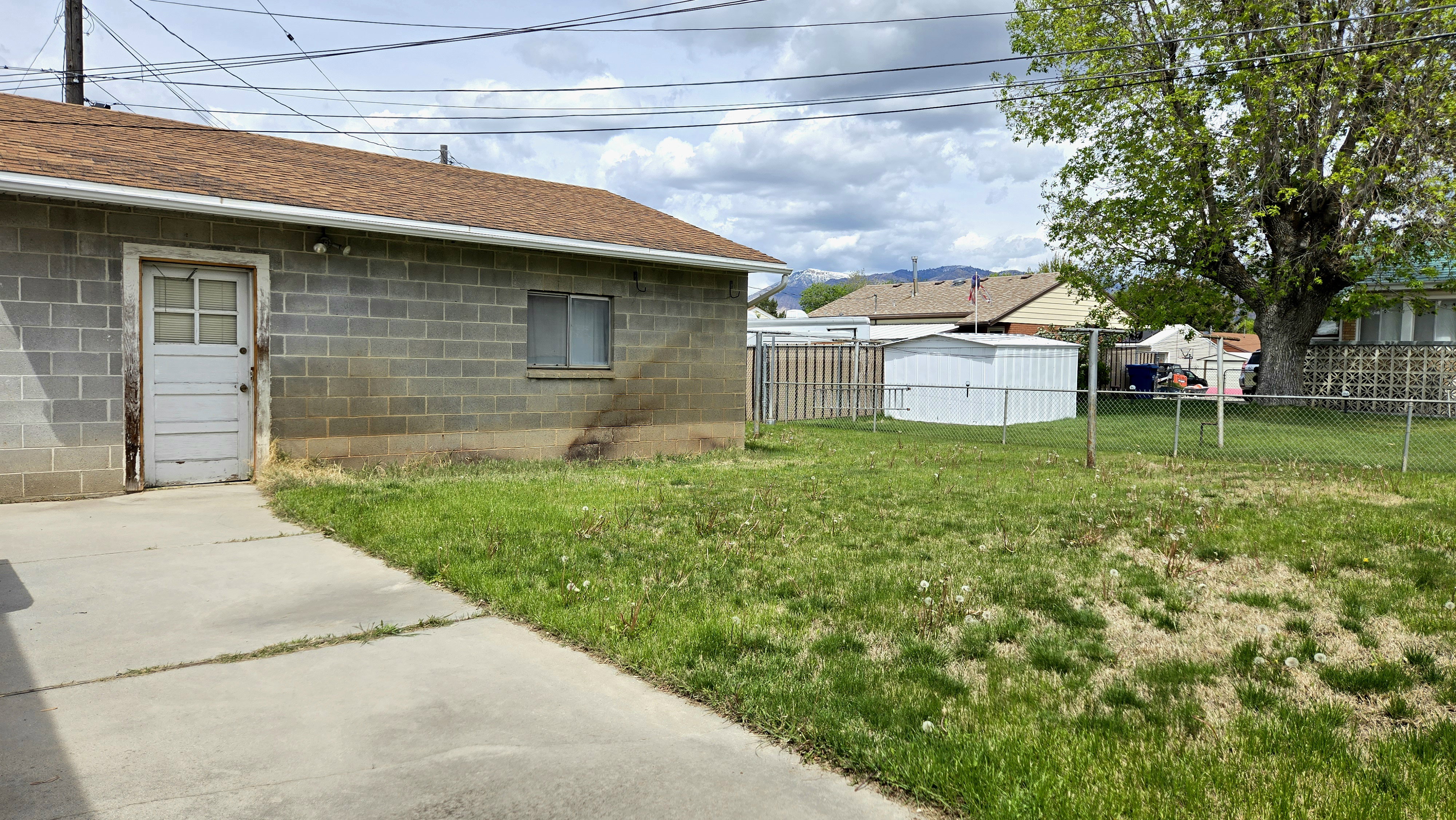 Fenced backyard with an outbuilding
