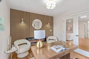 Dining area with an accent wall, french doors, wood finished floors, wallpapered walls, and a desk
