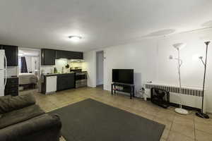 Living area with radiator heating unit and light tile patterned flooring