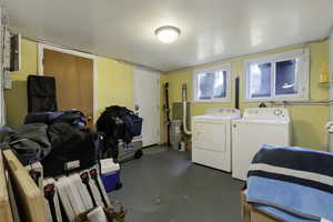 Laundry area with washer and dryer and concrete floors
