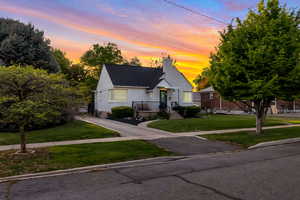 Bungalow-style home featuring a front lawn and a chimney