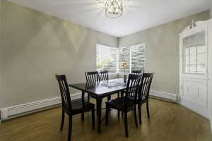 Dining room with wood finished floors and a baseboard radiator