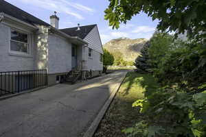View of side of home featuring a chimney and a mountain view