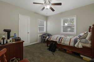 Bedroom with dark carpet and ceiling fan