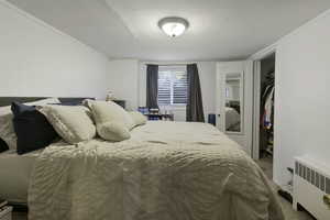 Bedroom with radiator and a closet