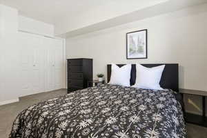 Bedroom with dark colored carpet and a closet
