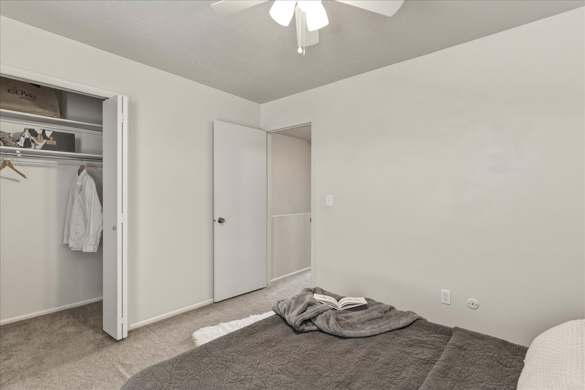 Unfurnished bedroom with carpet floors, ceiling fan, and a closet