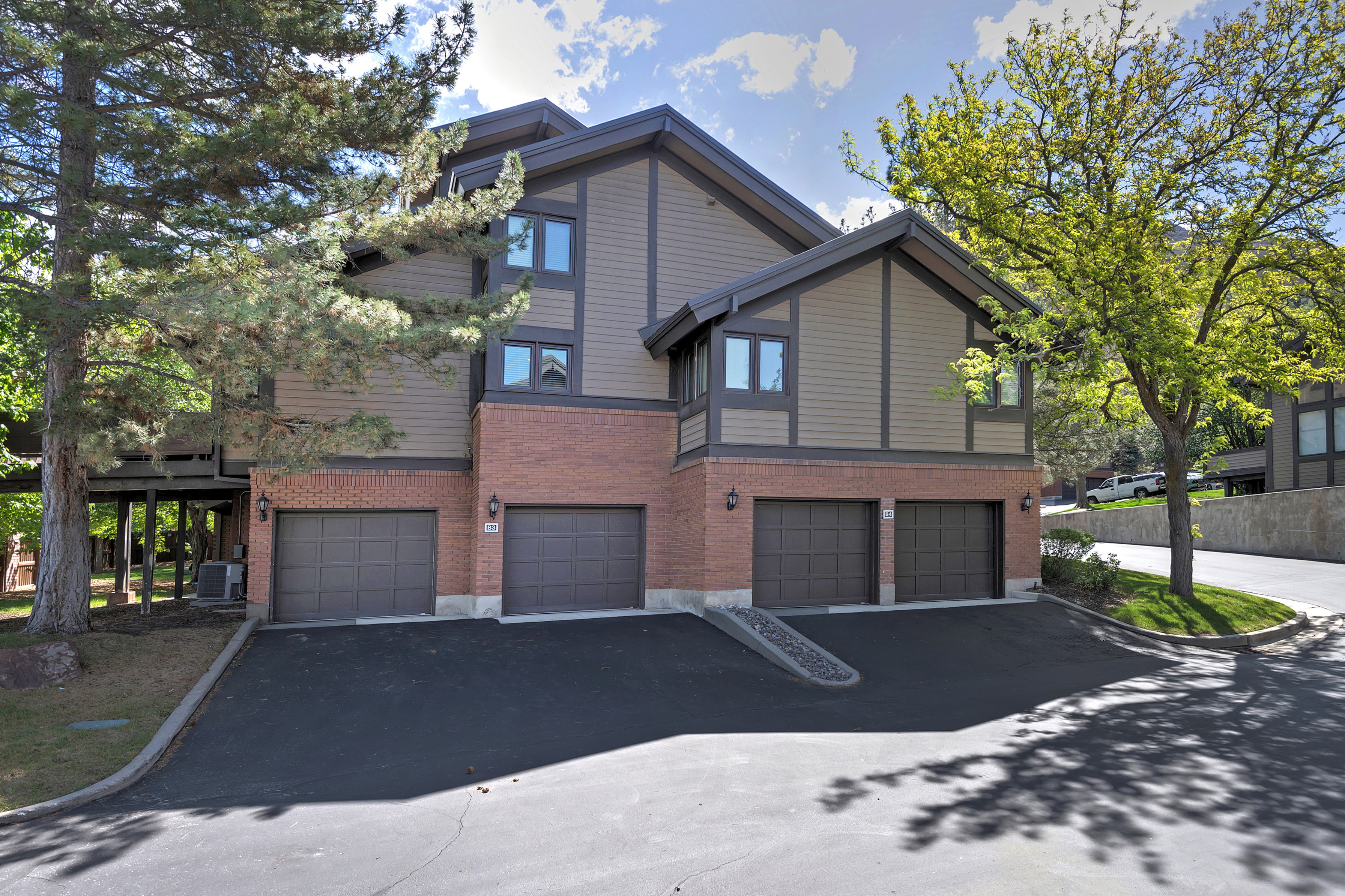 View of front of house with brick siding, an attached garage, and driveway