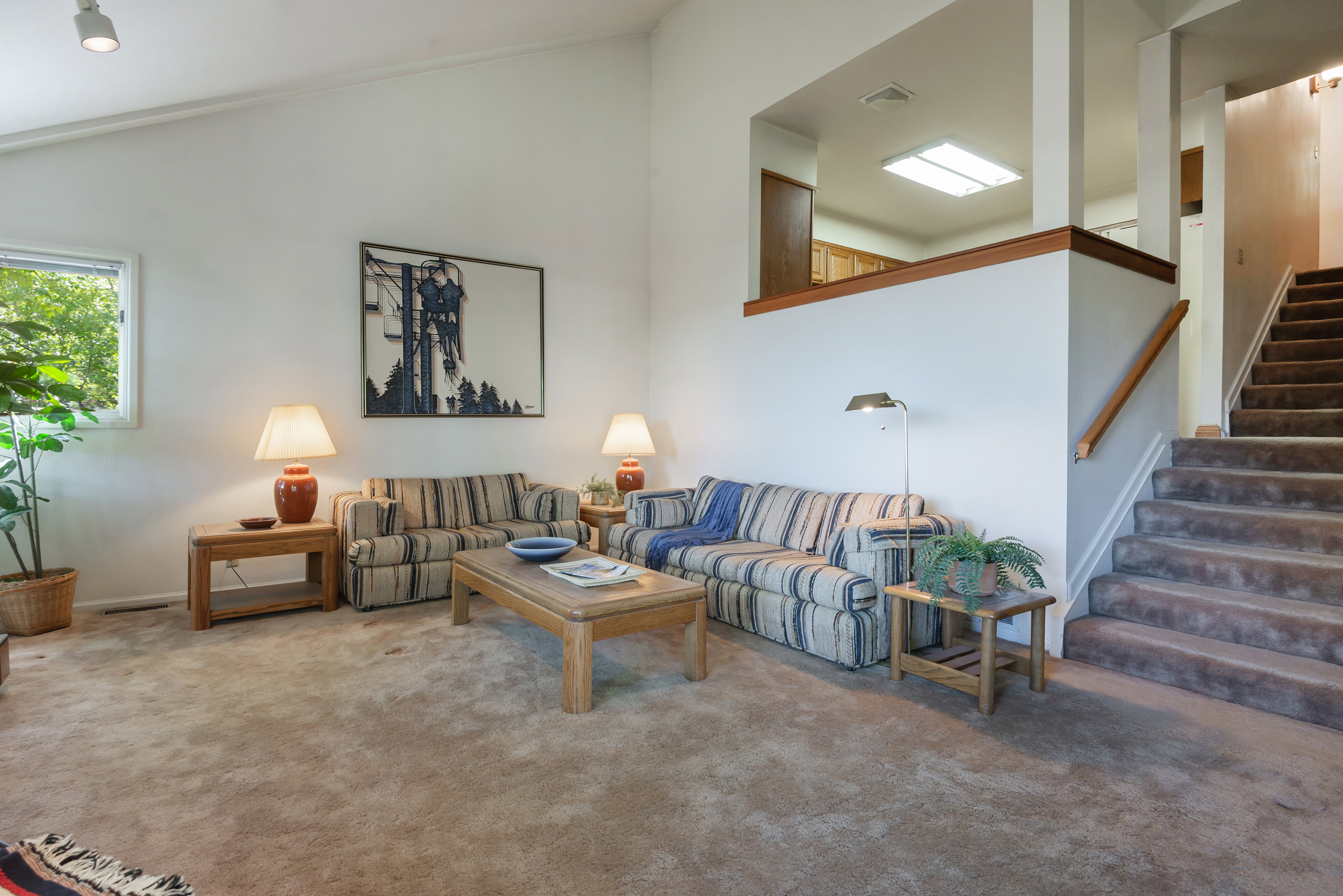 Living room with carpet floors and vaulted ceiling