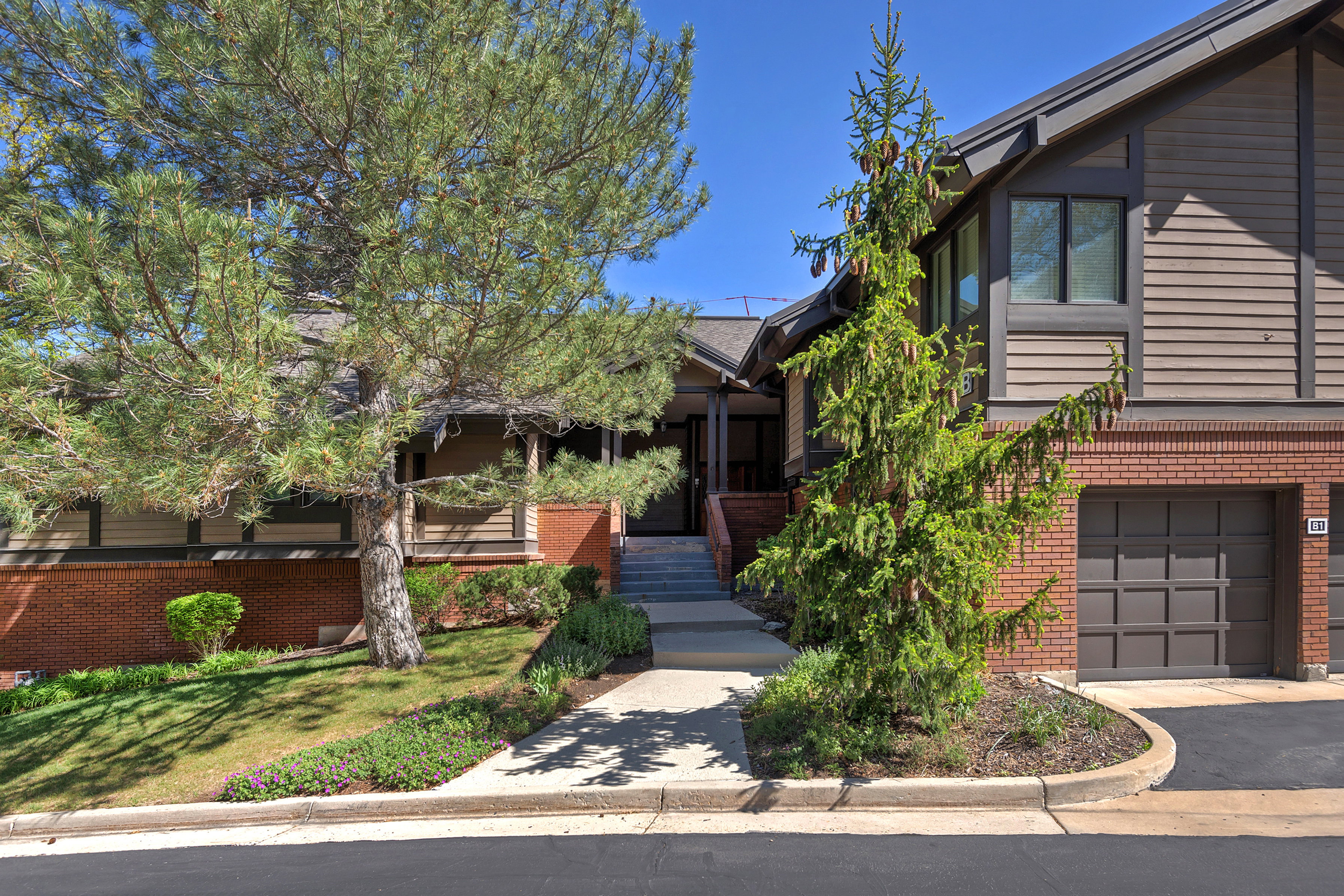 View of front of house featuring brick siding, an attached garage, and driveway