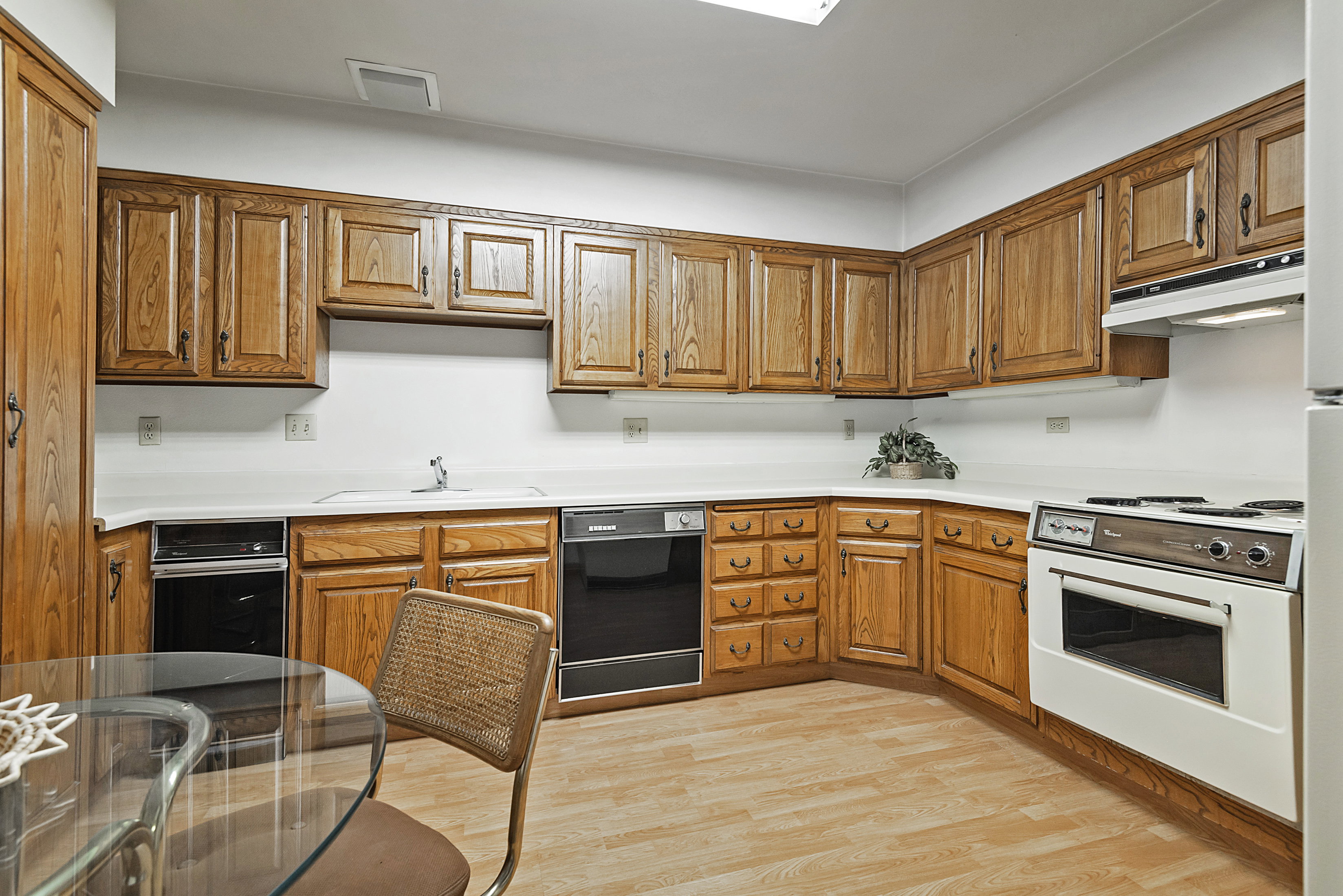 Kitchen with light countertops, wood finish cabinetry, and light wood-type flooring