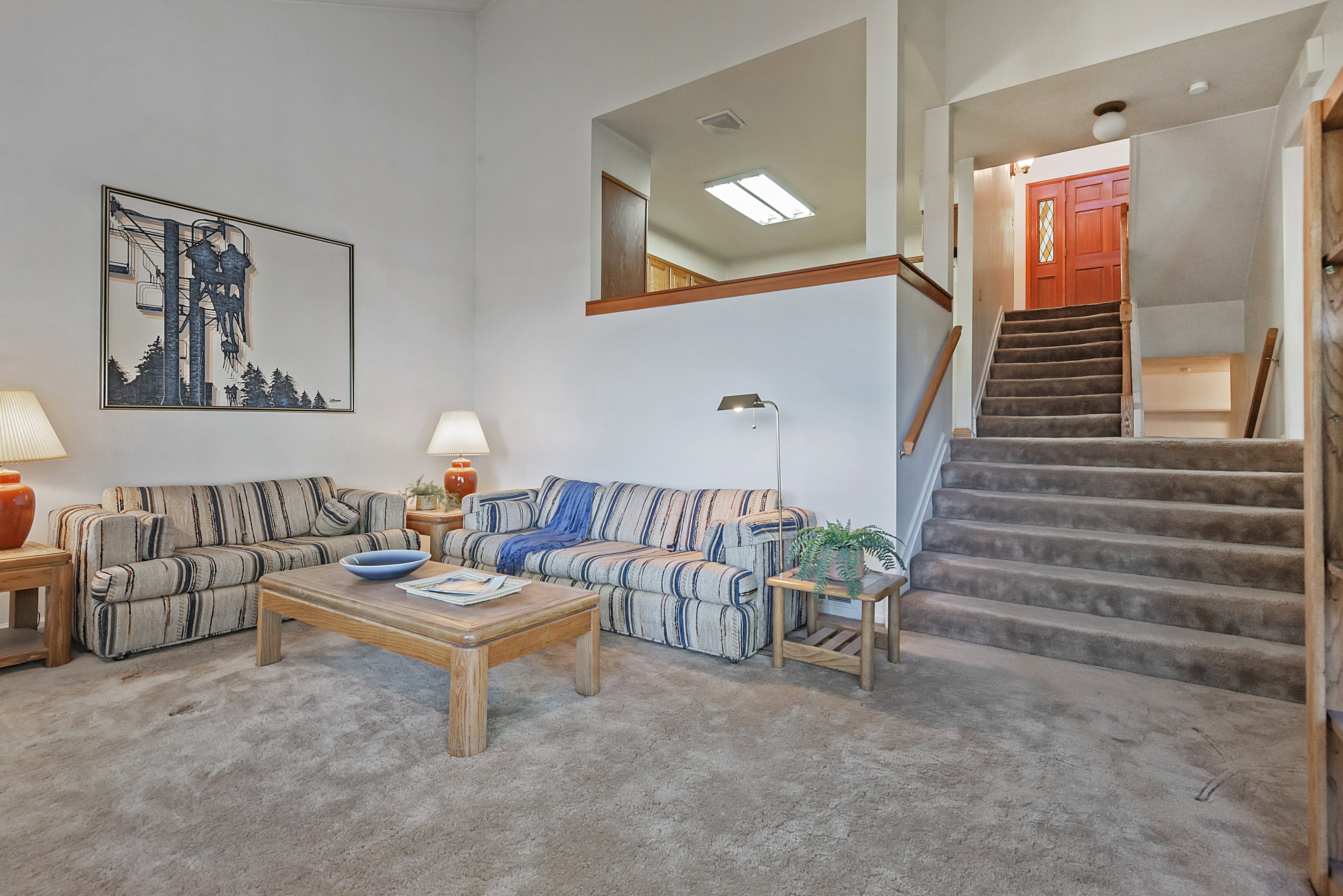 Living area with carpet and a high ceiling