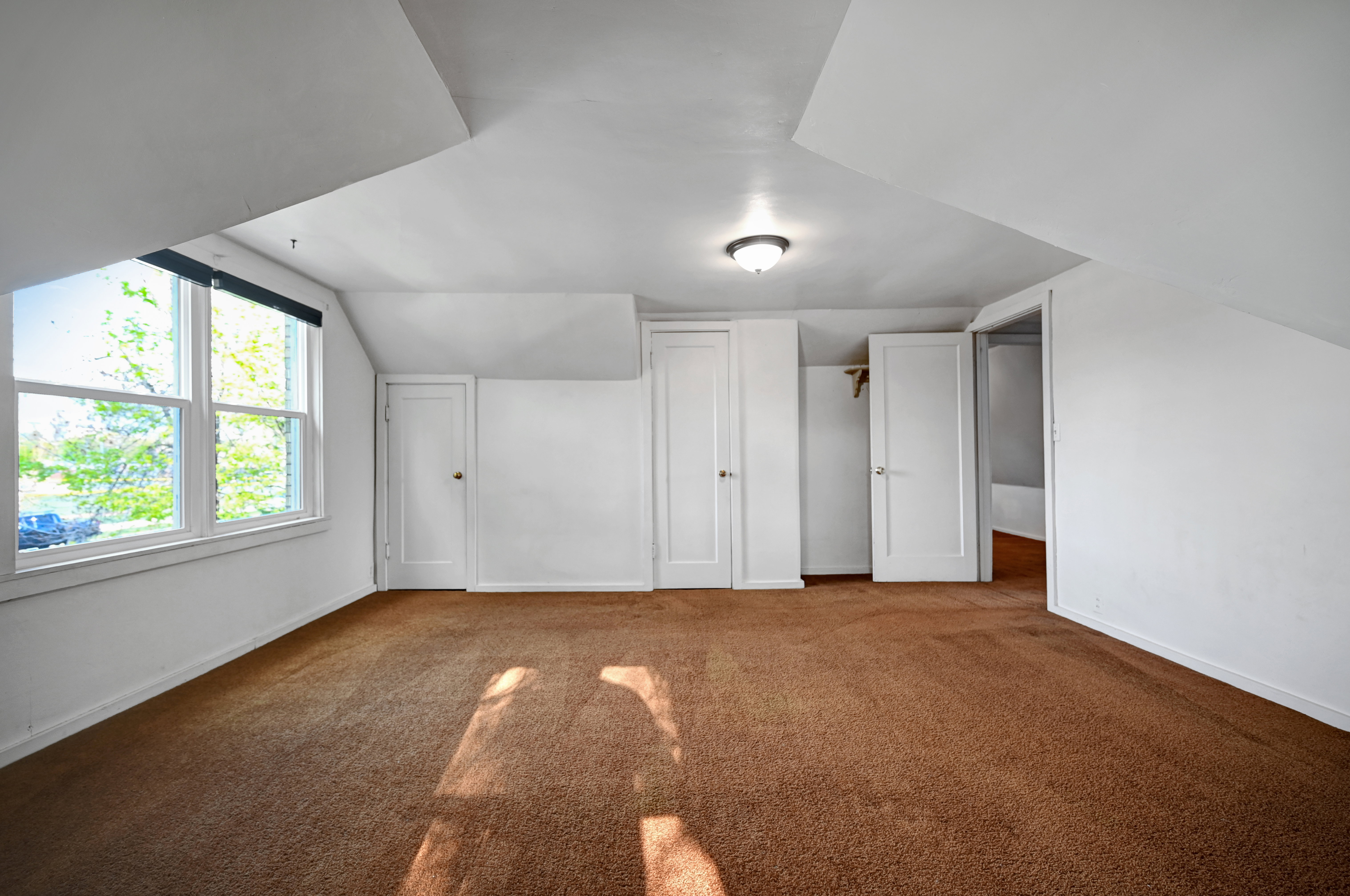 Bonus room featuring dark colored carpet and lofted ceiling