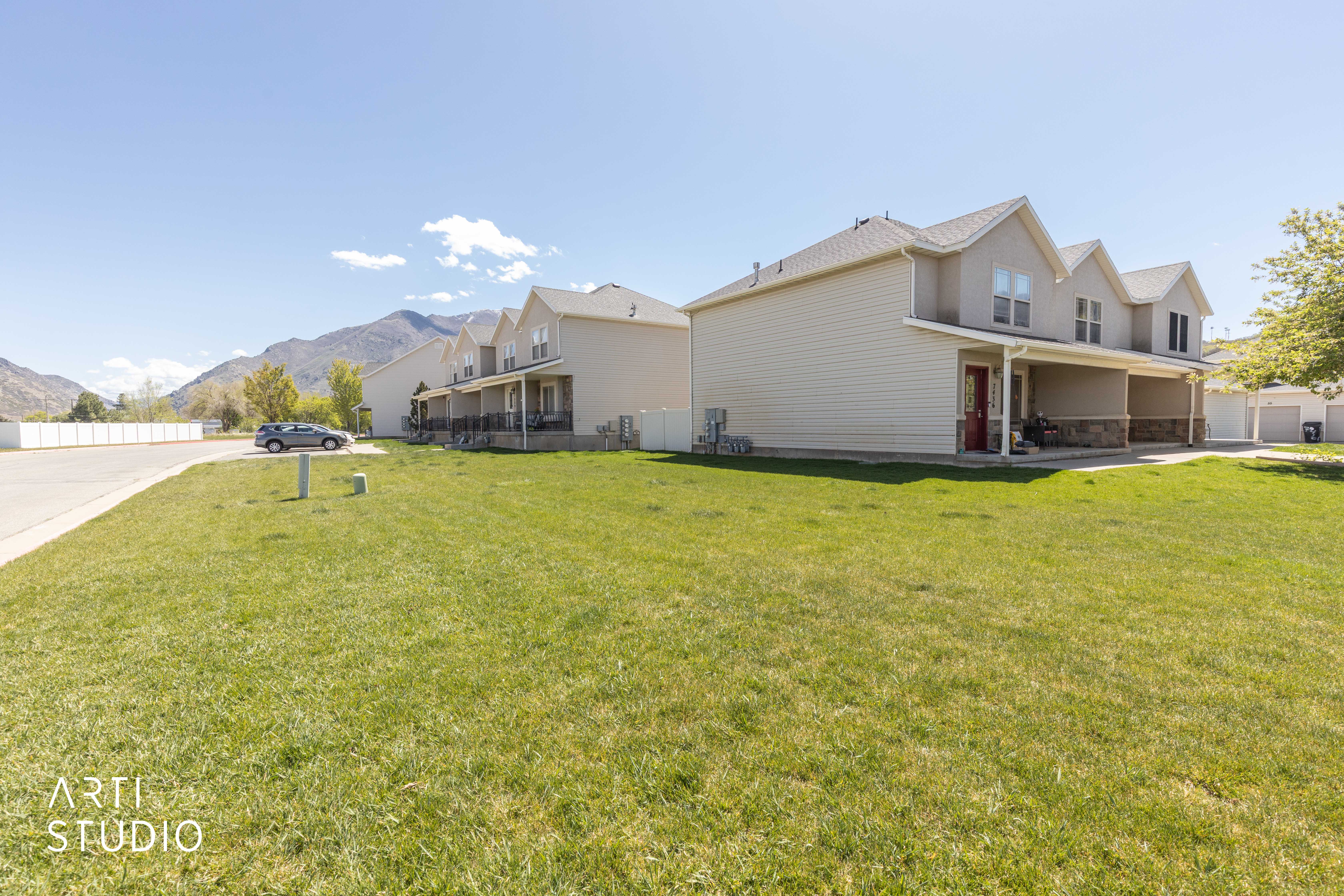 View of side of home featuring a mountain view, a patio, and stone siding