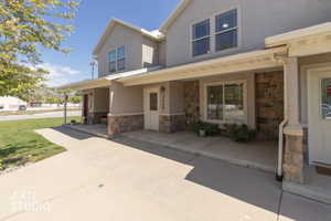 View of front of town home with stone siding and porch.