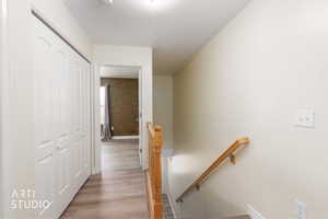 Hall with an upstairs landing and light wood-type flooring