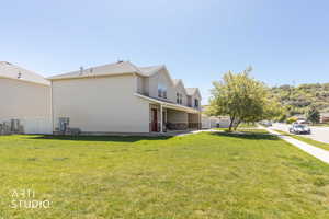View of home's exterior with a lawn and a patio area