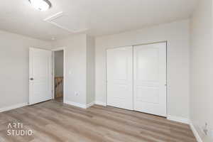 Unfurnished bedroom featuring light wood-style floors and a closet